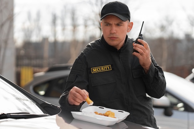 Retrato do guarda de segurança masculino tendo uma pausa para o almoço