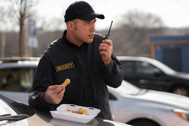 Retrato do guarda de segurança masculino tendo uma pausa para o almoço