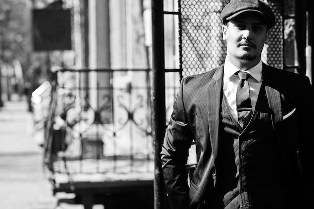 Retrato do homem de negócios árabe inglês dos anos 20 retrô usando gravata de terno escuro e boné plano