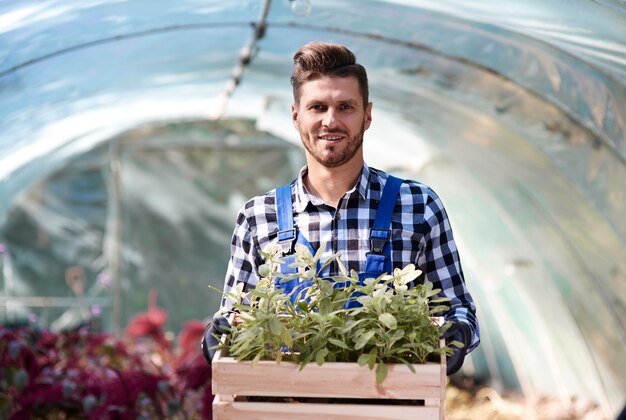 Retrato do jardineiro segurando uma caixa de madeira com mudas