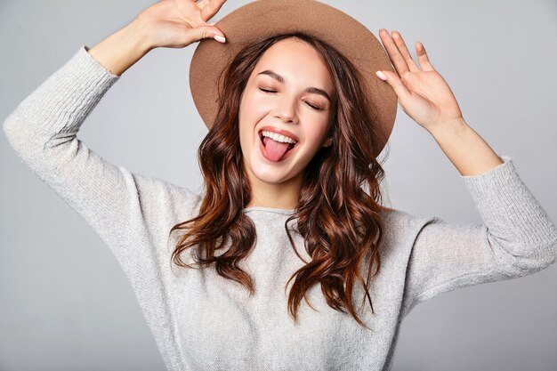 Retrato do jovem modelo rindo elegante em roupas de verão casual cinza com chapéu marrom com maquiagem natural