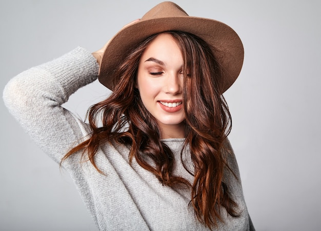 Retrato do jovem modelo rindo elegante em roupas de verão casual cinza com chapéu marrom com maquiagem natural