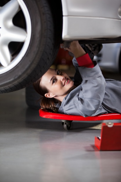 Retrato do mecânico fêmea que repara um carro