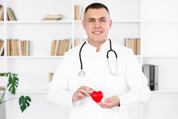 Foto grátis retrato do médico homem segurando um coração de pelúcia