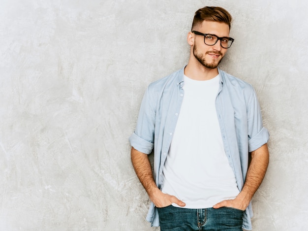 Retrato do modelo bonito jovem sorridente, vestindo roupas de camisa casual. homem elegante moda posando em espetáculos