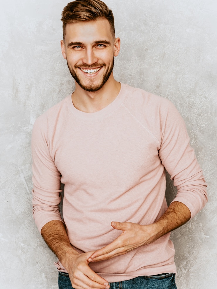 Foto grátis retrato do modelo bonito jovem sorridente, vestindo roupas de verão casual rosa. moda elegante homem posando
