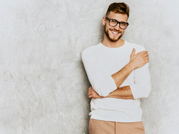 Retrato do modelo de empresário de hipster sorridente bonito vestindo roupas de verão casual branco.