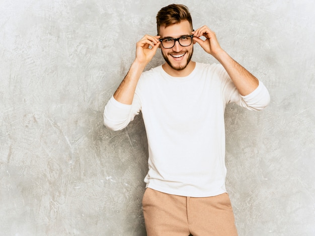 Retrato do modelo de empresário de hipster sorridente bonito vestindo roupas de verão casual branco.