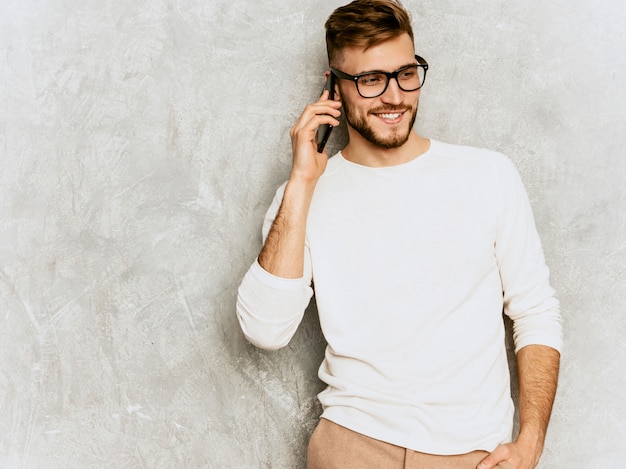 Retrato do modelo de empresário de hipster sorridente bonito vestindo roupas de verão casual branco.