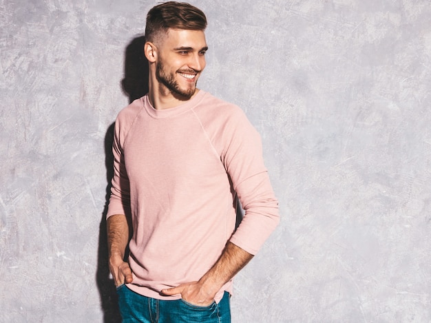 Retrato do modelo de empresário de hipster sorridente bonito vestindo roupas de verão casual rosa.