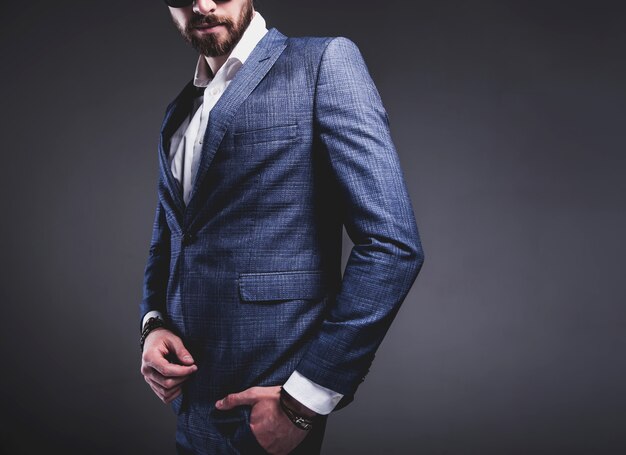 retrato do modelo de empresário de moda hipster elegante bonito vestido com elegante terno azul na cinza