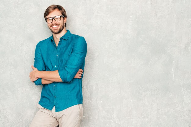 Retrato do modelo de empresário lumbersexual hipster sorridente bonito, vestindo roupas de camisa jeans casual.