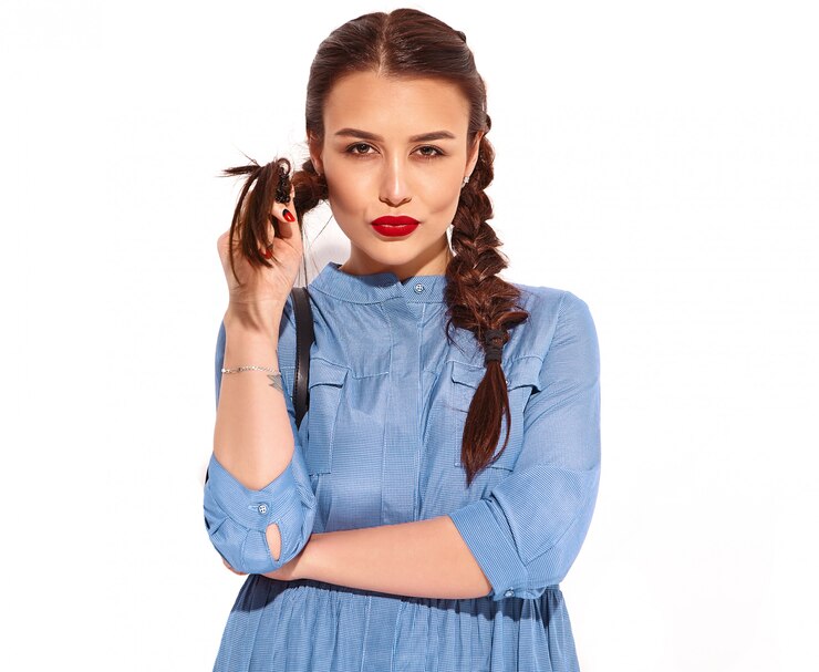 Foto grátis retrato do modelo de jovem sorridente feliz com maquiagem brilhante e lábios vermelhos com duas tranças nas mãos no vestido azul colorido do verão