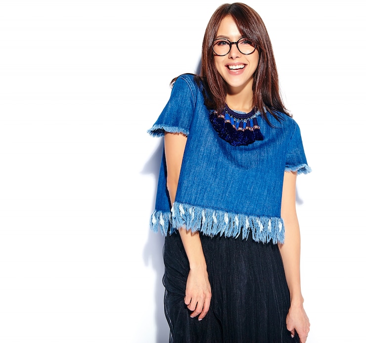 Foto grátis retrato do modelo de mulher morena sorridente hipster inteligente bonita no casual elegante azul jeans roupas e óculos isolados no branco
