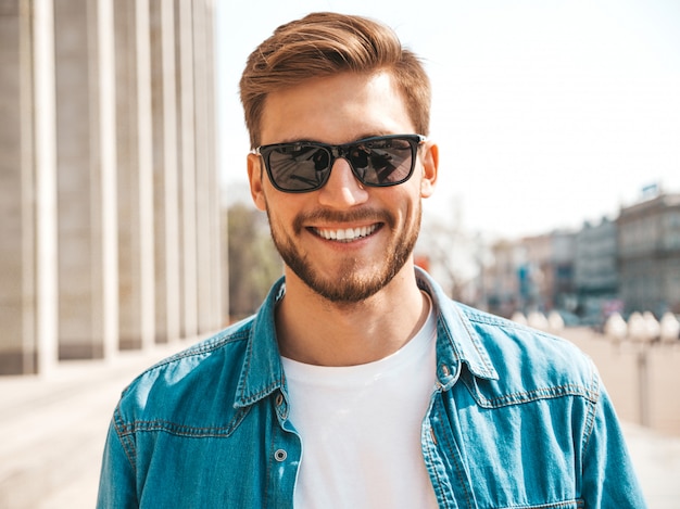 Retrato do modelo de sorriso bonito do homem de negócios lumbersexual do moderno à moda. homem vestido com roupas de jaqueta jeans.