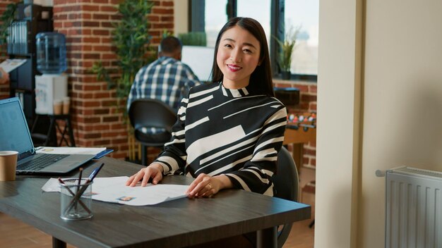 Retrato do recrutador de RH asiático analisando o currículo do candidato antes da reunião de entrevista de emprego. Mulher de negócios se preparando para a nomeação de aplicativo de trabalho com recruta no escritório da empresa.