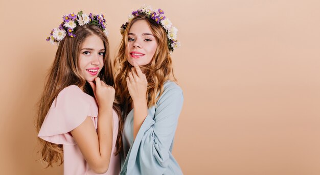 Retrato em close-up de duas lindas mulheres em vestidos da moda, isolado em um fundo claro