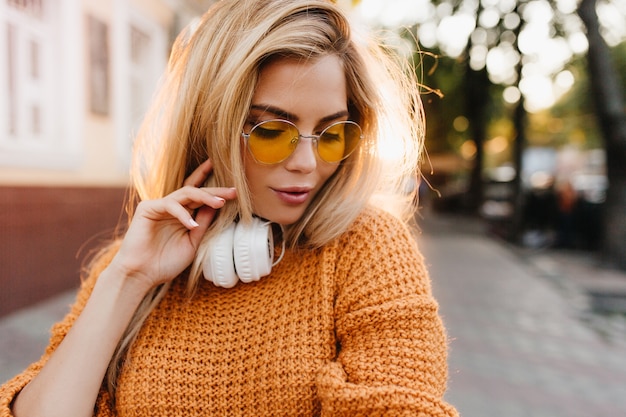 Retrato em close-up de modelo feminina levemente bronzeada olhando para baixo com expressão facial tímida