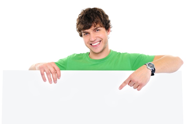 Retrato em close-up de um homem feliz sob uma faixa em branco e mostrando com o dedo