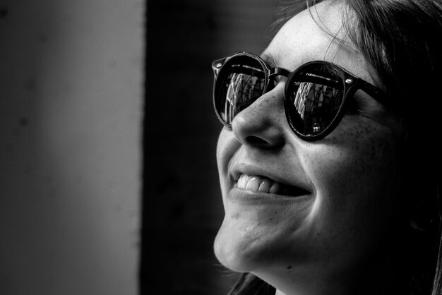 Retrato em preto e branco de mulher usando óculos escuros