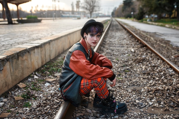 Retrato estético pop punk de mulher posando em trilhos de trem