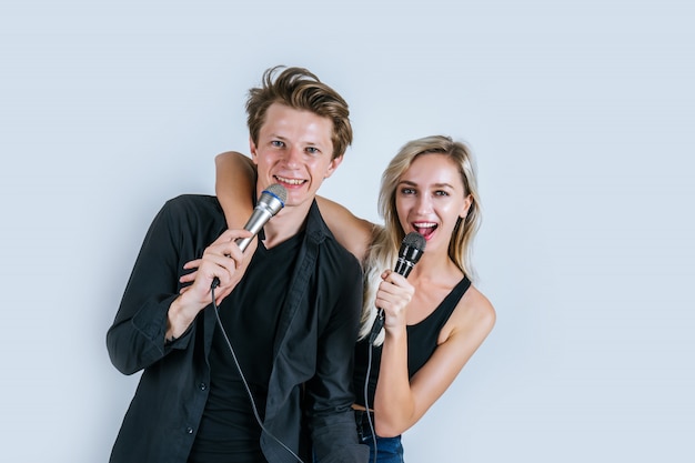 Foto grátis retrato feliz do casal segurando o microfone e cantar uma canção