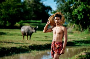Retrato homem jovem em topless usando armadilha de bambu para pescar peixes para cozinhar