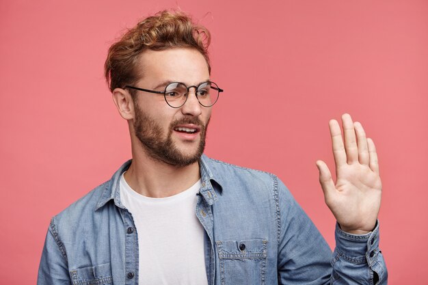 Retrato interno de jovem barbudo com penteado da moda