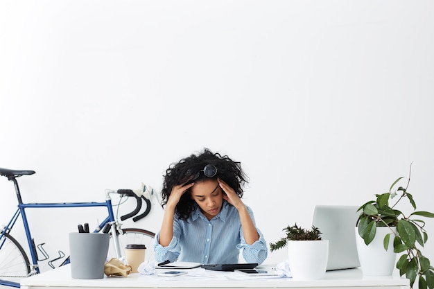 Foto grátis retrato interno de jovem empresária cansada e sobrecarregada de trabalho se sentindo estressada