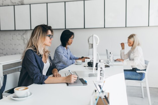 Retrato interno de jovens desenvolvedores da web de empresa internacional em pausa para o café