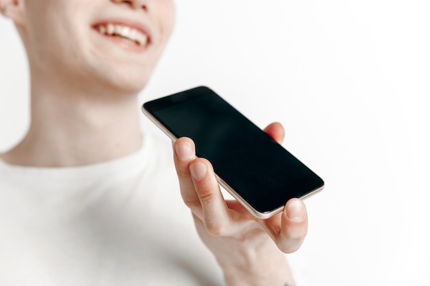 Foto grátis retrato interno de um jovem atraente segurando um smartphone