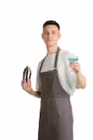 Foto grátis retrato isolado de um jovem barista ou barman caucasiano com avental marrom sorrindo