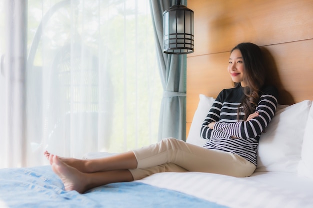 Retrato jovem mulher asiática feliz relaxar sorriso na decoração da cama no quarto