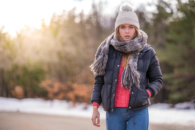 Retrato Jovem mulher bonita em uma estrada com neve no inverno