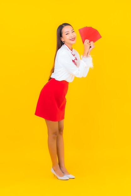 Retrato linda jovem asiática com carta de envelopes vermelhos no ano novo chinês em amarelo.