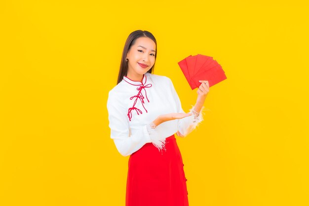 Retrato linda jovem asiática com carta de envelopes vermelhos no ano novo chinês em amarelo.