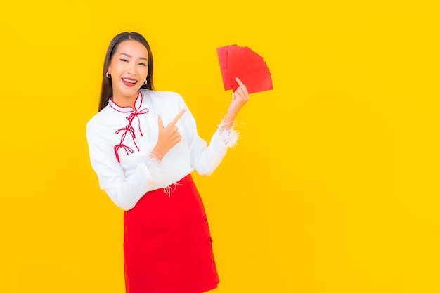 Retrato linda jovem asiática com carta de envelopes vermelhos no ano novo chinês em amarelo.