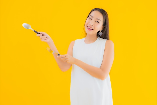 Retrato linda jovem asiática com colher de garfo