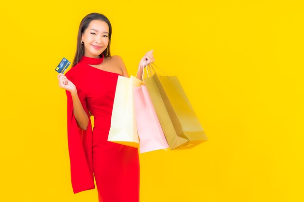 Retrato linda jovem asiática com sacola de compras e cartão de crédito.