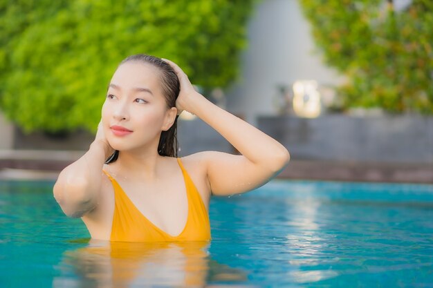 Retrato linda jovem asiática relaxando ao ar livre na piscina em viagem de férias