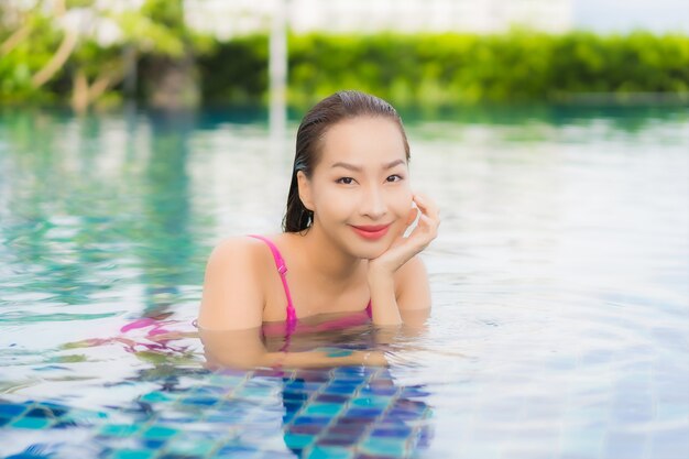 Retrato linda jovem asiática relaxando e aproveitando a piscina ao ar livre nas férias