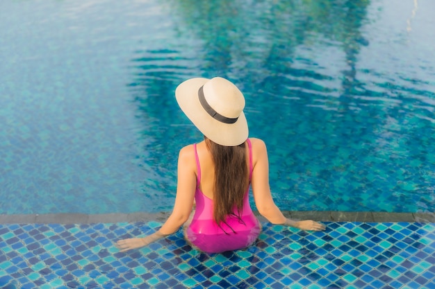 Retrato linda jovem asiática relaxando e aproveitando a piscina ao ar livre nas férias