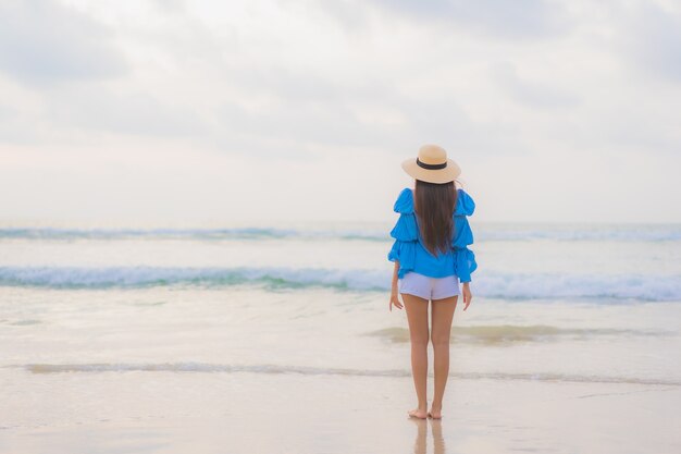 Retrato linda jovem asiática relaxando lazer sorriso ao redor da praia, mar, oceano, hora do sol