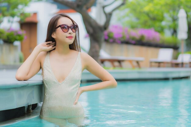 Retrato linda jovem asiática relaxando sorriso ao redor da piscina