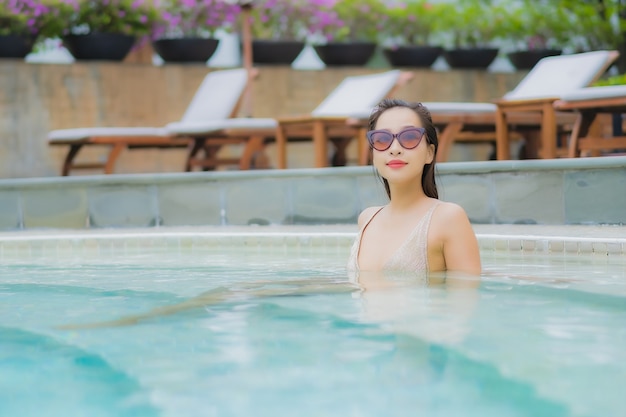 Retrato linda jovem asiática relaxando sorriso ao redor da piscina