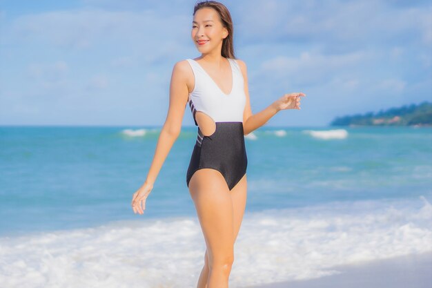 Retrato linda jovem asiática relaxando sorriso ao redor da praia, mar, oceano, nas férias