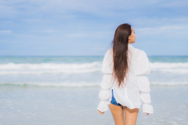 Foto grátis retrato linda jovem asiática relaxando sorriso ao redor da praia, mar, oceano, numa viagem de férias de férias