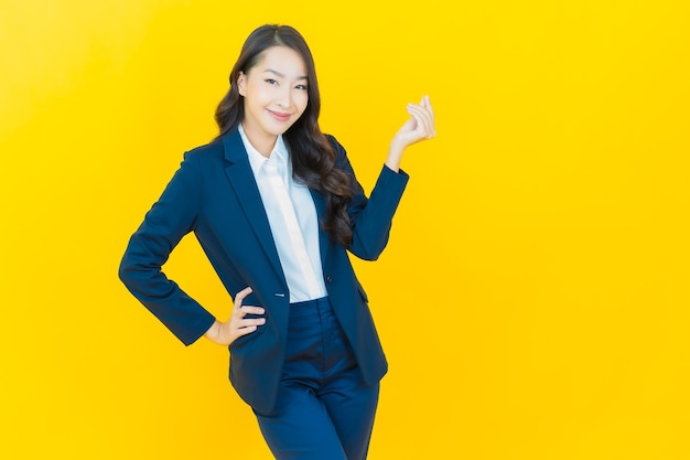 Retrato linda jovem asiática sorrindo com ação em amarelo