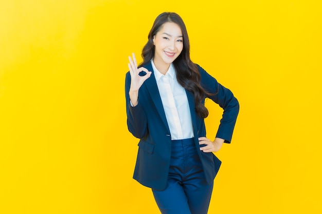 Retrato linda jovem asiática sorrindo com ação em amarelo