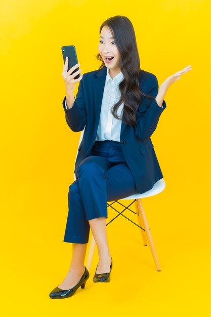 Retrato linda jovem asiática sorrindo com ação em amarelo